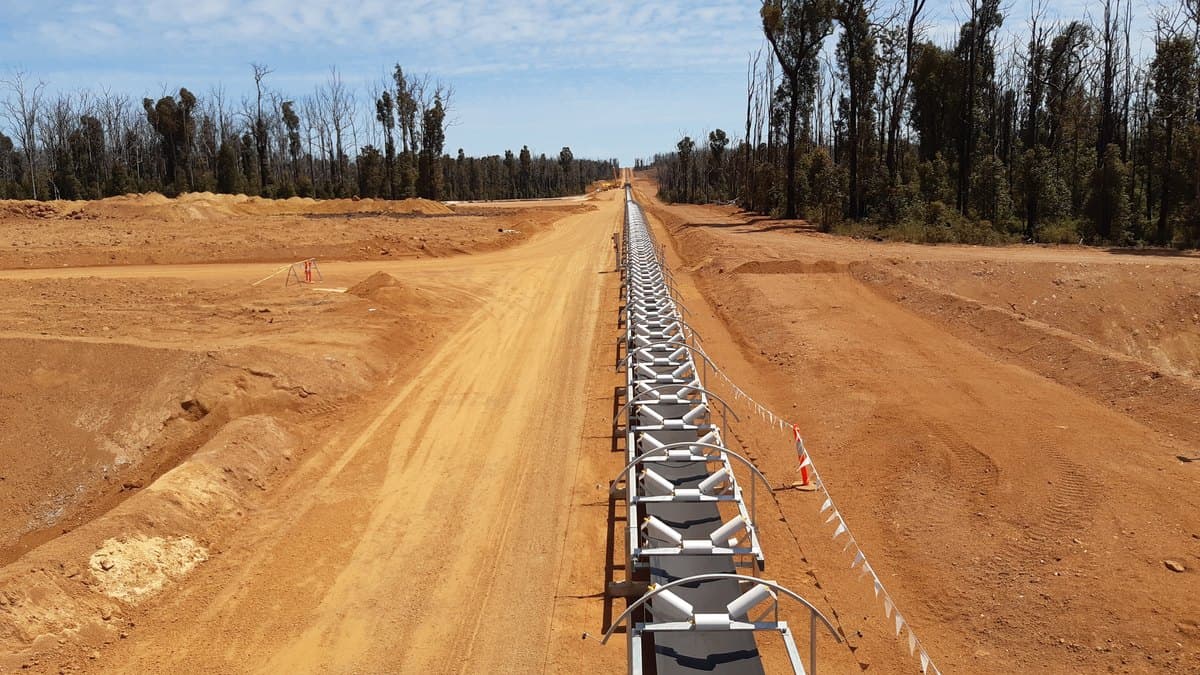 Transportador de banda overland en construcción a través del terreno escarpado de una faena minera