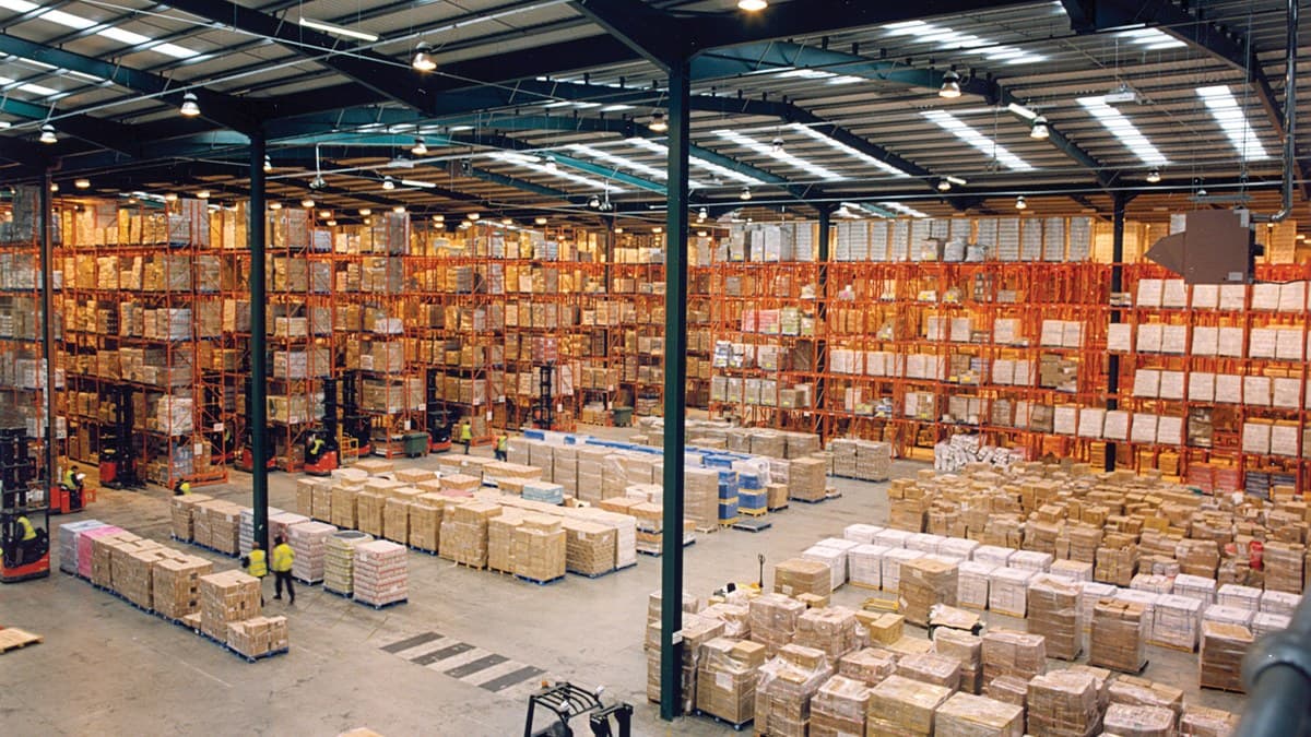 Centro de distribución y almacén industrial con estanterías de alta capacidad y montacargas para suministro de cables mineros