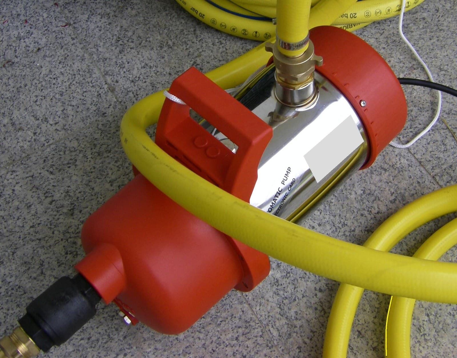Bomba sumergible eléctrica conectada con manguera de impulsión, válvula antirretorno y cable redondo negro H07RN8-F.