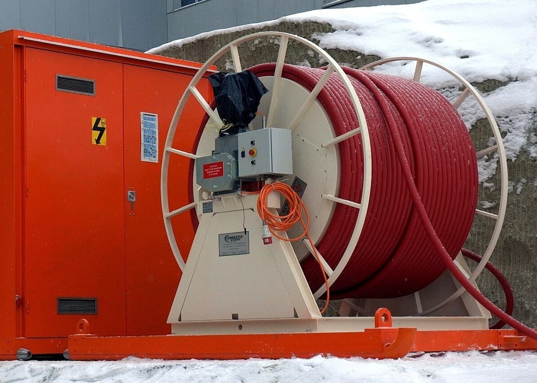 Fotografía real de tambor motorizado con cable portátil de potencia de uso extra rudo conectado a subestación móvil en condiciones climáticas extremas