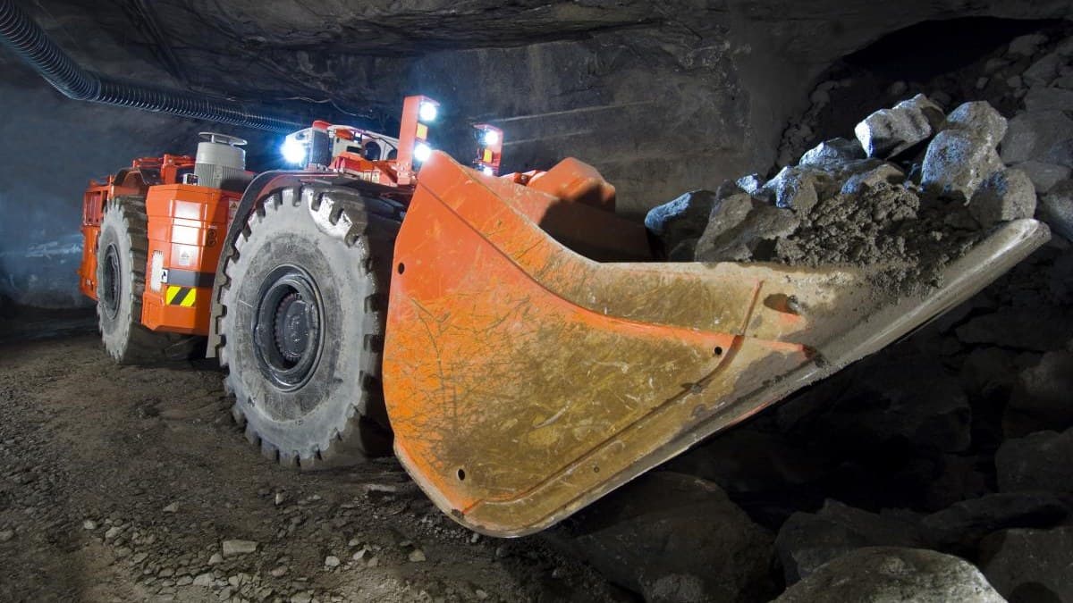 Cargador subterráneo LHD cargando mineral en frente de avance con cable de arrastre minero de uso rudo