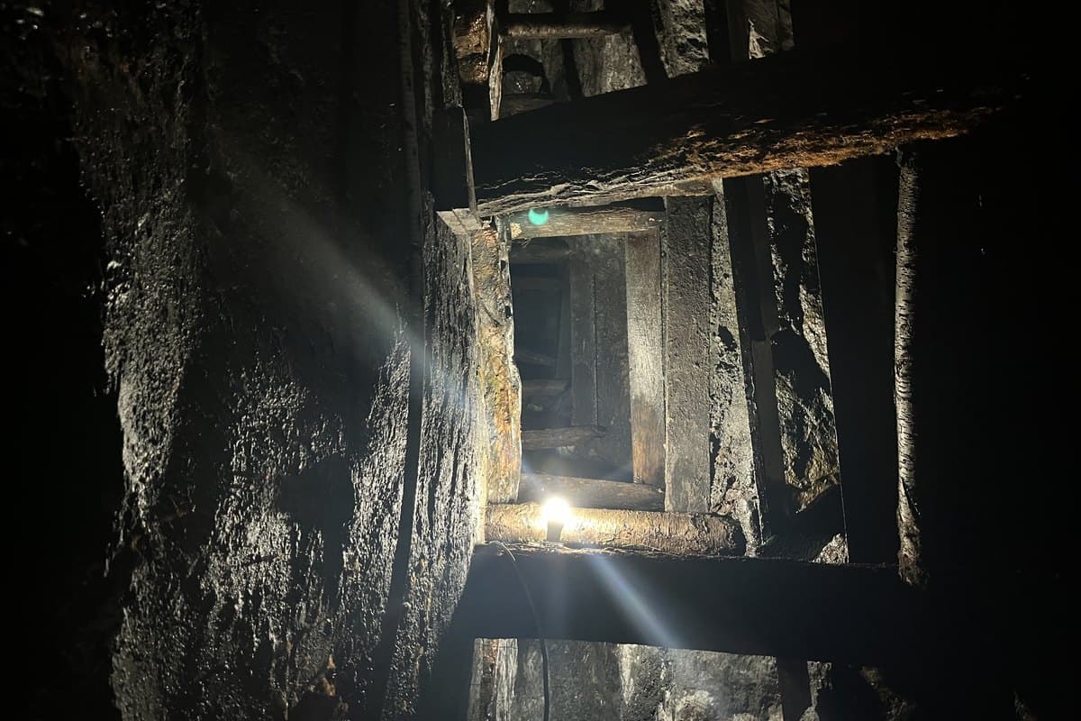 Galería de mina subterránea con tendido de cables de energía y luminarias a lo largo de las estructuras de soporte