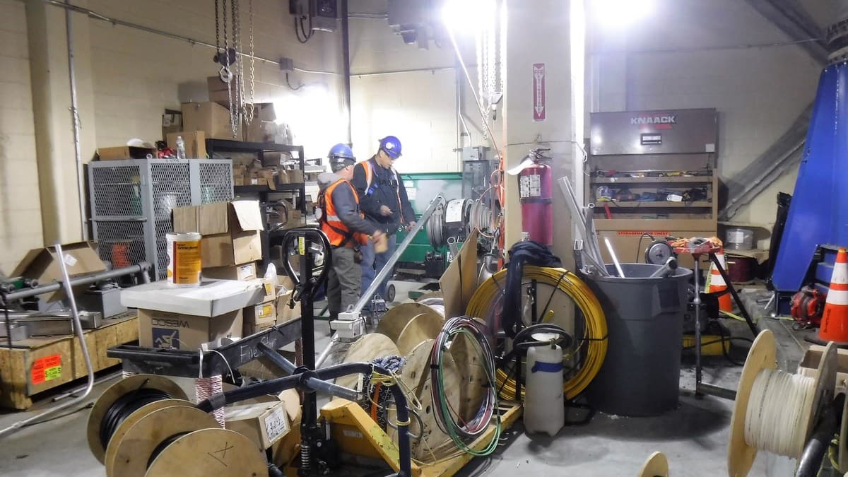 Técnicos electricistas instalando sistemas de canalización y puesta a tierra de seguridad en subestación de potencia minera