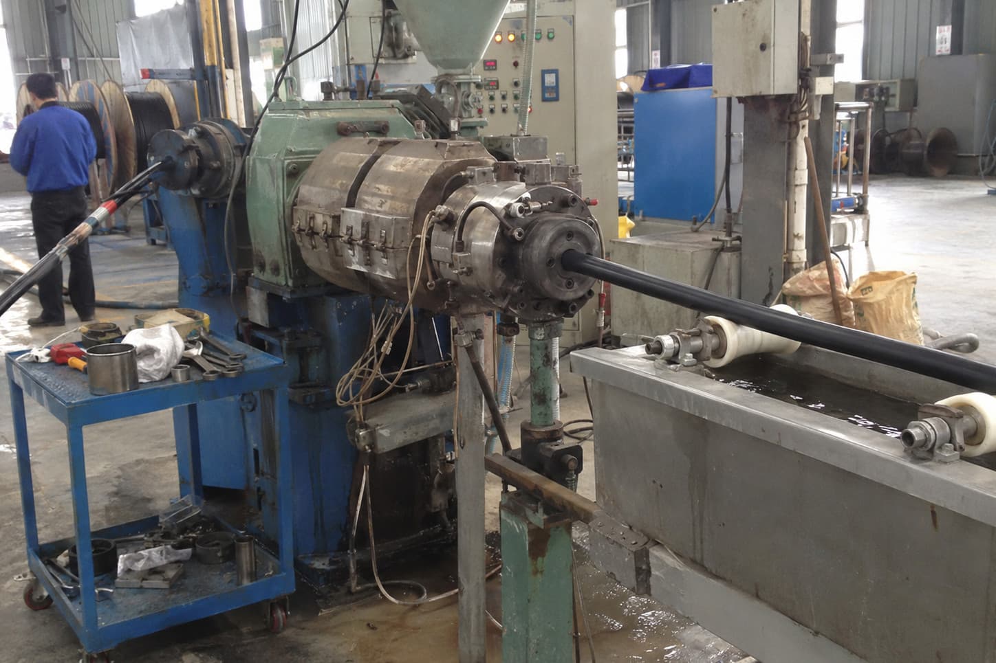 Extrusión de la cubierta exterior y tina de enfriamiento